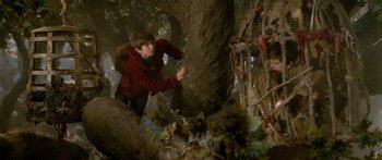 Movie still from “The Spiderwick Chronicles” (2008), directed by Mark Waters – A young man climbing a tree in the woods; Wide shot, Low angle