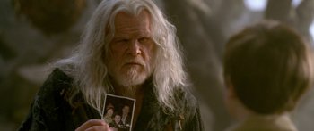Movie still from “The Spiderwick Chronicles” (2008), directed by Mark Waters – An old man with long white hair holding up a picture; Close Up shot, Over the shoulder angle