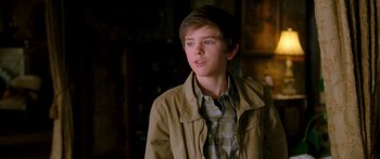 Movie still from “The Spiderwick Chronicles” (2008), directed by Mark Waters – A young man wearing a brown jacket looking to his left; Close Up shot, Over the shoulder angle