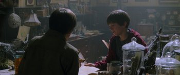 Movie still from “The Spiderwick Chronicles” (2008), directed by Mark Waters – Two young boys sitting at a table in a room; Medium shot, Over the shoulder angle