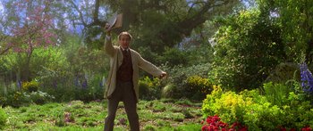 Movie still from “The Spiderwick Chronicles” (2008), directed by Mark Waters – A man in a suit and tie holding a frisbee; Medium shot, Low angle