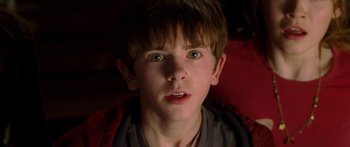 Movie still from “The Spiderwick Chronicles” (2008), directed by Mark Waters – A young boy with green eyes stares into the camera; Close Up shot, Over the shoulder angle