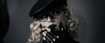 Movie still from “The Spirit” (2008), directed by Frank Miller – A person wearing glasses and a hat; Close Up shot, Low angle