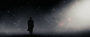 Movie still from “The Spirit” (2008), directed by Frank Miller – A man in a hat and a long coat standing in the fog; Extreme Wide shot, Low angle