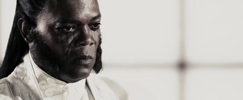 Movie still from “The Spirit” (2008), directed by Frank Miller – A black man with black eyes and a white shirt; Close Up shot, Low angle