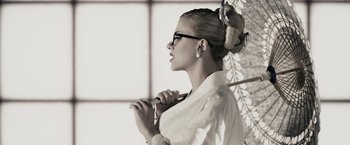 Movie still from “The Spirit” (2008), directed by Frank Miller – A woman with glasses holding an open umbrella; Close Up shot, Low angle