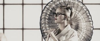 Movie still from “The Spirit” (2008), directed by Frank Miller – A woman holding an open umbrella in front of a window; Close Up shot, Low angle