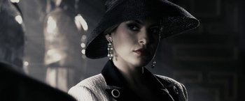 Movie still from “The Spirit” (2008), directed by Frank Miller – A woman wearing a black hat and a white jacket; Close Up shot, Low angle