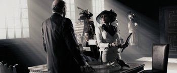Movie still from “The Spirit” (2008), directed by Frank Miller – A man and a woman are standing in a room; Medium shot, Over the shoulder angle