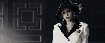 Movie still from “The Spirit” (2008), directed by Frank Miller – A woman wearing a black hat and a white jacket; Close Up shot, Low angle