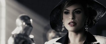 Movie still from “The Spirit” (2008), directed by Frank Miller – A woman wearing a black hat and a white jacket; Close Up shot, Over the shoulder angle