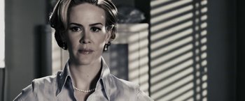 Movie still from “The Spirit” (2008), directed by Frank Miller – A black and white photo of a woman in a dress shirt and pearl necklace; Close Up shot, Over the shoulder angle