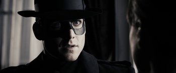 Movie still from “The Spirit” (2008), directed by Frank Miller – A person wearing a hat and eye glasses; Close Up shot, Low angle