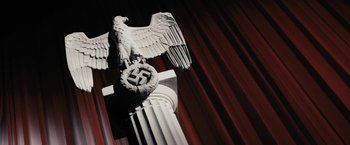 Movie still from “The Spirit” (2008), directed by Frank Miller – An eagle statue on top of a pillar with a swastika on it; Medium shot, Low angle