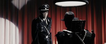 Movie still from “The Spirit” (2008), directed by Frank Miller – A man in a military uniform talking to another man in a uniform; Medium shot, Over the shoulder angle