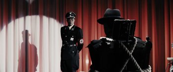 Movie still from “The Spirit” (2008), directed by Frank Miller – A man in a nazi uniform standing in front of another man in a hat; Medium shot, Over the shoulder angle