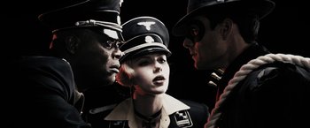 Movie still from “The Spirit” (2008), directed by Frank Miller – A group of people in military garb talking to each other; Close Up shot, Low angle