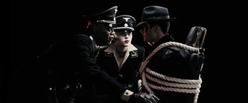 Movie still from “The Spirit” (2008), directed by Frank Miller – A group of men standing next to each other; Medium shot, Overhead angle