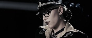 Movie still from “The Spirit” (2008), directed by Frank Miller – A woman in a uniform smoking a cigarette and wearing glasses; Close Up shot, Low angle