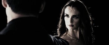 Movie still from “The Spirit” (2008), directed by Frank Miller – A beautiful woman with long dark hair wearing a necklace; Close Up shot, Over the shoulder angle