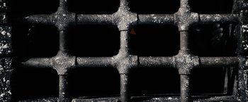 Movie still from “The Spirit” (2008), directed by Frank Miller – View of a black pipe with a red triangle on it; Extreme Close Up shot, Overhead angle