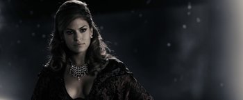 Movie still from “The Spirit” (2008), directed by Frank Miller – A woman with long hair wearing a necklace and a dress; Close Up shot, Over the shoulder angle