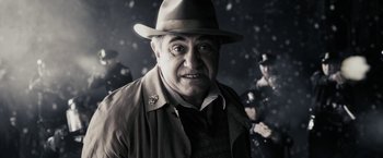 Movie still from “The Spirit” (2008), directed by Frank Miller – An older man wearing a hat and a coat; Close Up shot, Low angle