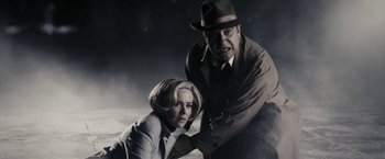 Movie still from “The Spirit” (2008), directed by Frank Miller – A man and a woman posing for a picture; Medium shot, Low angle