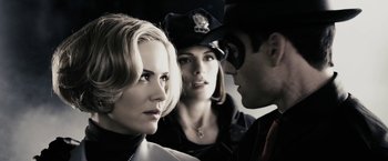 Movie still from “The Spirit” (2008), directed by Frank Miller – Two women and a man in a police uniform; Close Up shot, Over the shoulder angle