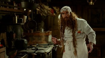 Movie still from “The SpongeBob Movie: Sponge Out of Water” (2015), directed by Mike Mitchell – A man with long hair and a long beard is cooking in a kitchen; Medium shot, Low angle