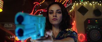 Movie still from “The Spy Who Dumped Me” (2018), directed by Susanna Fogel – A woman is holding a gun in front of lights; Close Up shot, Low angle