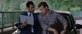 Movie still from “The Spy Who Dumped Me” (2018), directed by Susanna Fogel – Two men looking at a tablet in a car; Medium shot, Over the shoulder angle