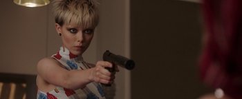 Movie still from “The Spy Who Dumped Me” (2018), directed by Susanna Fogel – A woman holding a gun while standing in front of a wall; Close Up shot, Over the shoulder angle