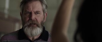 Movie still from “The Spy Who Dumped Me” (2018), directed by Susanna Fogel – An older man with a beard and a mustache; Close Up shot, Over the shoulder angle