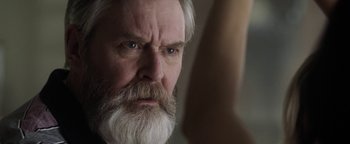 Movie still from “The Spy Who Dumped Me” (2018), directed by Susanna Fogel – An older man with a white beard looking at the camera; Close Up shot, Over the shoulder angle
