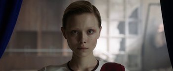 Movie still from “The Spy Who Dumped Me” (2018), directed by Susanna Fogel – A young boy with short blonde hair stares into the camera; Close Up shot, Low angle