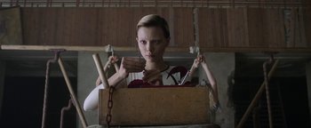Movie still from “The Spy Who Dumped Me” (2018), directed by Susanna Fogel – A woman is holding a wooden box with a bunch of tools in it; Medium shot, Low angle