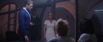 Movie still from “The Spy Who Dumped Me” (2018), directed by Susanna Fogel – A woman in a white dress standing next to two men; Medium shot, Over the shoulder angle