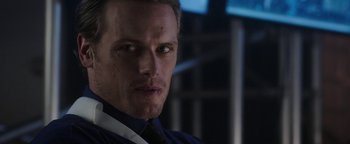 Movie still from “The Spy Who Dumped Me” (2018), directed by Susanna Fogel – A person wearing a suit and tie; Close Up shot, Over the shoulder angle