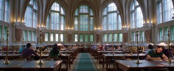 Movie still from “The Spy Who Dumped Me” (2018), directed by Susanna Fogel – People are sitting at tables in a large room; Extreme Wide shot, Low angle