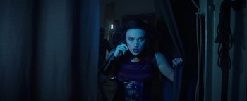 Movie still from “The Spy Who Dumped Me” (2018), directed by Susanna Fogel – A woman in a dark room talking on a phone; Medium shot, Low angle