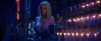 Movie still from “The Spy Who Dumped Me” (2018), directed by Susanna Fogel – A woman sitting at a table in front of a glass of wine; Medium shot, Over the shoulder angle