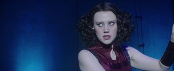Movie still from “The Spy Who Dumped Me” (2018), directed by Susanna Fogel – A person with curly hair wearing a dress; Close Up shot, Over the shoulder angle