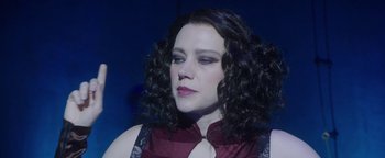 Movie still from “The Spy Who Dumped Me” (2018), directed by Susanna Fogel – A person with curly hair wearing a dress; Close Up shot, Low angle