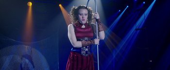 Movie still from “The Spy Who Dumped Me” (2018), directed by Susanna Fogel – A woman holding a pole in front of a crowd; Medium shot, Low angle