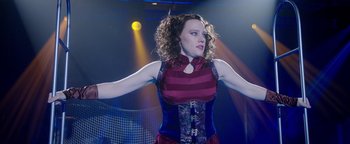 Movie still from “The Spy Who Dumped Me” (2018), directed by Susanna Fogel – A woman in a red and blue striped top is performing a dance; Medium shot, Low angle