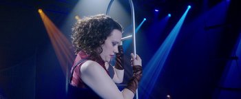 Movie still from “The Spy Who Dumped Me” (2018), directed by Susanna Fogel – A woman with curly brown hair wearing gloves and a red top; Medium shot, Low angle
