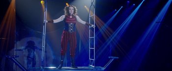 Movie still from “The Spy Who Dumped Me” (2018), directed by Susanna Fogel – A female circus performer is standing on a platform; Wide shot, Low angle