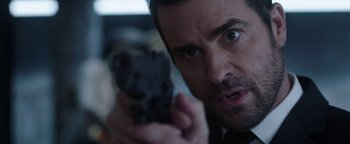 Movie still from “The Spy Who Dumped Me” (2018), directed by Susanna Fogel – A person holding a gun; Close Up shot, Over the shoulder angle