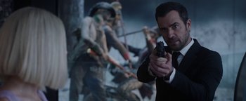 Movie still from “The Spy Who Dumped Me” (2018), directed by Susanna Fogel – A man holding a gun in front of a group of soldiers; Close Up shot, Over the shoulder angle
